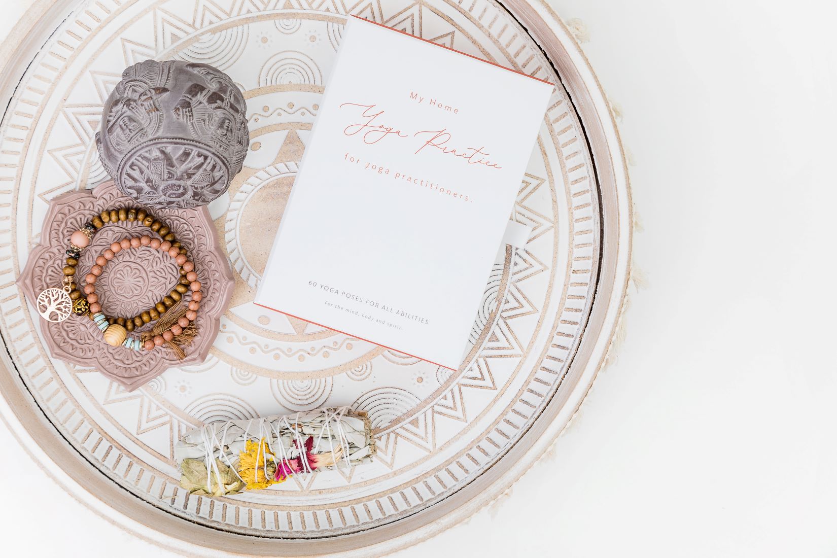 Yoga card deck on ethnic tray with malas and smudge stick made with dried flowers