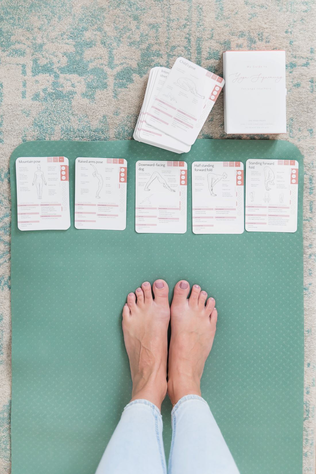 Yoga cards laid out on a yoga mat in a sequence ready for the yogi on the mat to start a home yoga practice