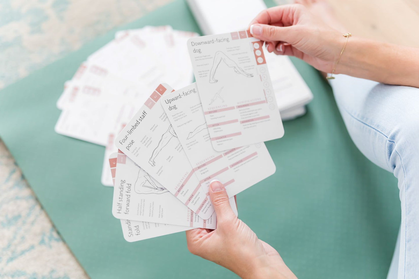 Yoga pose cards in a fan being selected by yogi preparing a yoga sequence
